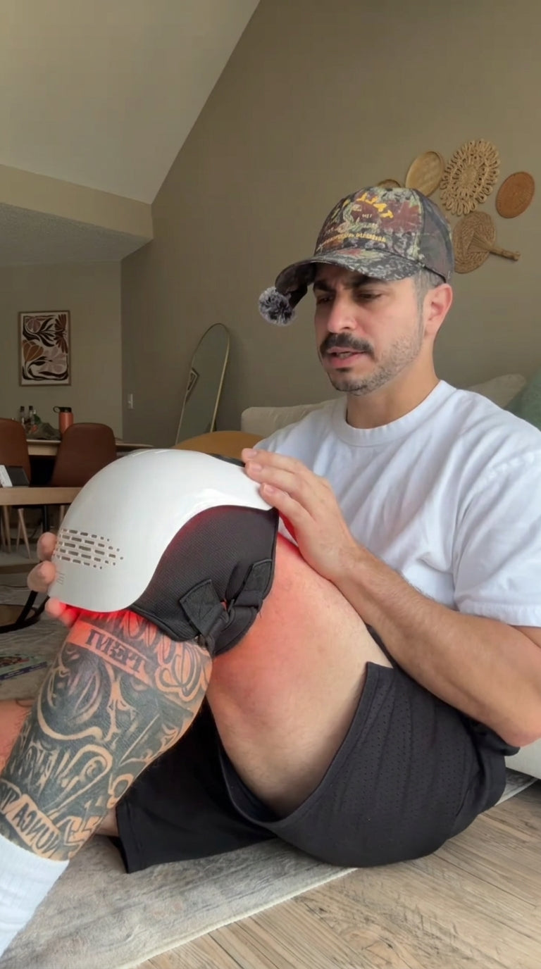 Athlete strapping a LEVIDE device onto his knee after a game